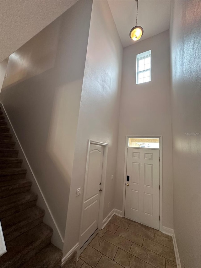 foyer entrance with tile patterned floors and a high ceiling