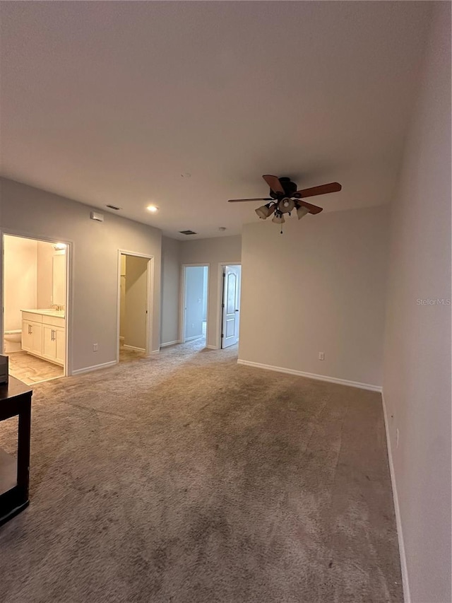 carpeted spare room featuring ceiling fan