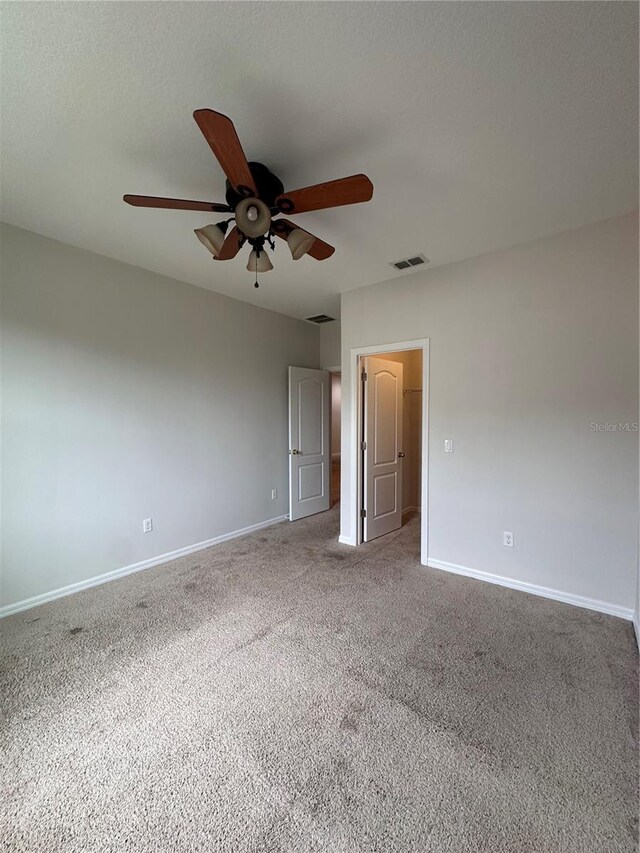 carpeted spare room featuring ceiling fan