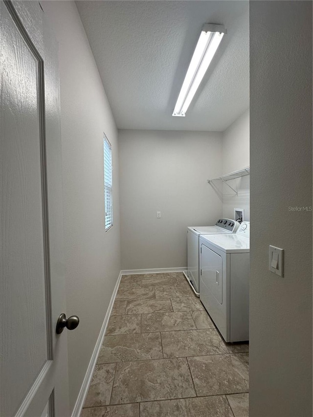 laundry area with washer and clothes dryer and a textured ceiling