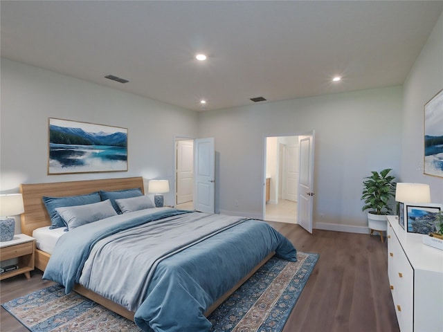 bedroom with hardwood / wood-style floors and ensuite bath