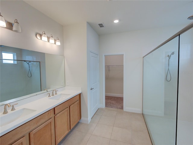 bathroom with tiled shower, vanity, and tile patterned floors