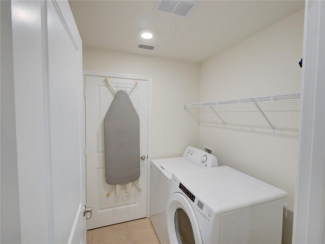 washroom featuring light tile patterned floors and washer and clothes dryer