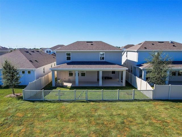 rear view of property featuring a lawn and a patio area