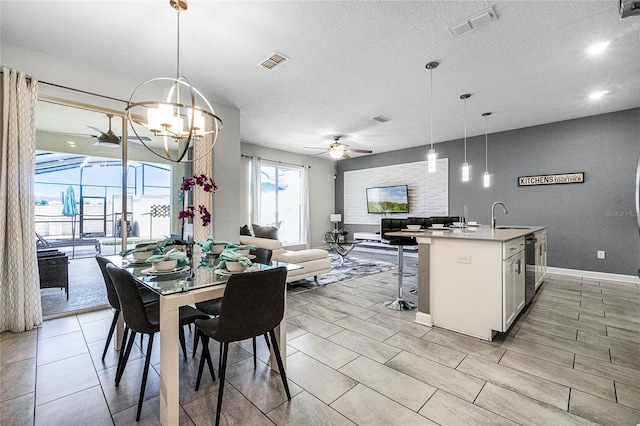 dining room featuring a textured ceiling, ceiling fan with notable chandelier, and sink