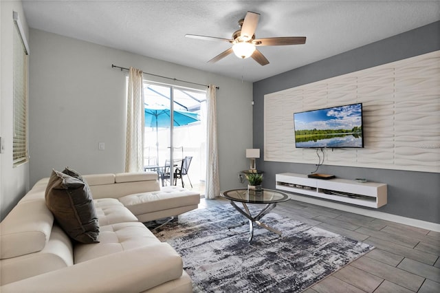 living room with ceiling fan, a textured ceiling, and hardwood / wood-style flooring