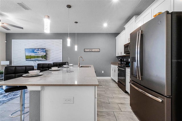 kitchen featuring pendant lighting, a kitchen island with sink, sink, and stainless steel appliances