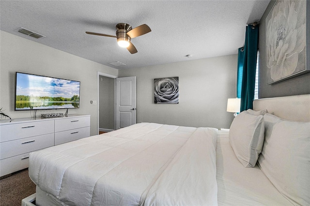 bedroom featuring a textured ceiling, carpet floors, and ceiling fan