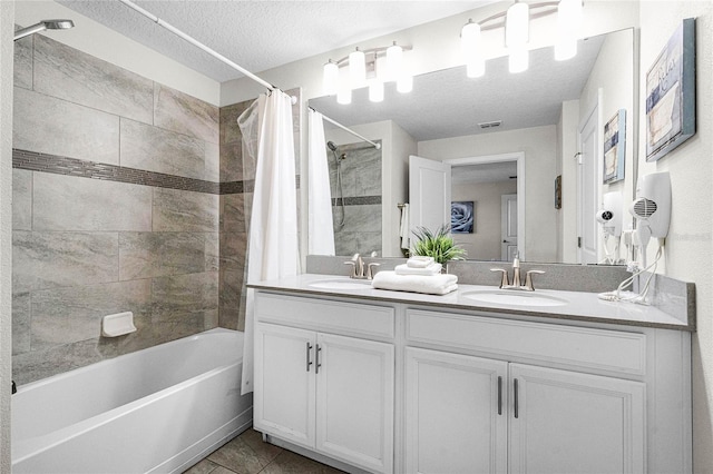 bathroom featuring tile patterned floors, shower / bath combo, a textured ceiling, and vanity