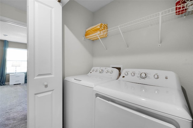 clothes washing area featuring washing machine and clothes dryer and carpet flooring