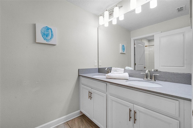 bathroom featuring vanity, a shower, a textured ceiling, and tile patterned floors