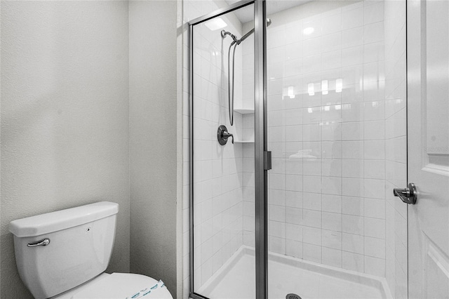 bathroom with toilet and a shower with shower door