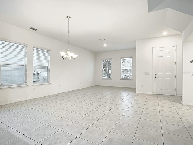 spare room with light tile patterned floors and a chandelier