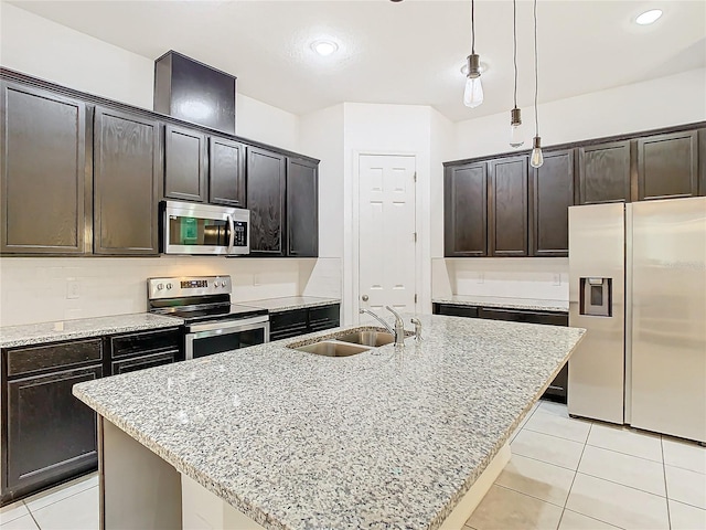 kitchen with sink, stainless steel appliances, decorative light fixtures, a kitchen island with sink, and dark brown cabinets