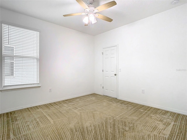 carpeted empty room featuring ceiling fan