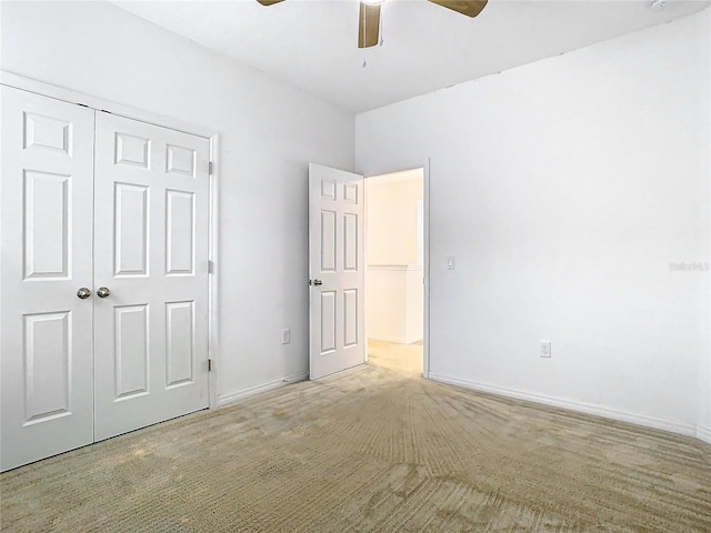 unfurnished bedroom with ceiling fan, light colored carpet, and a closet