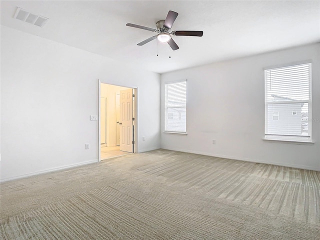 carpeted spare room featuring ceiling fan