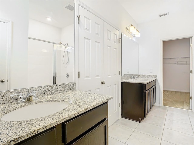 bathroom featuring tile patterned floors, vanity, and walk in shower