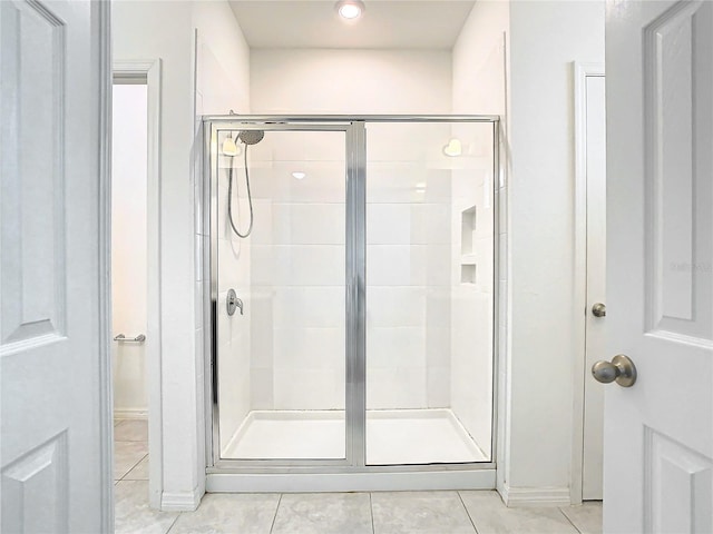 bathroom with tile patterned floors and a shower with shower door