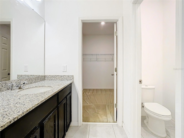 bathroom featuring tile patterned flooring, vanity, and toilet