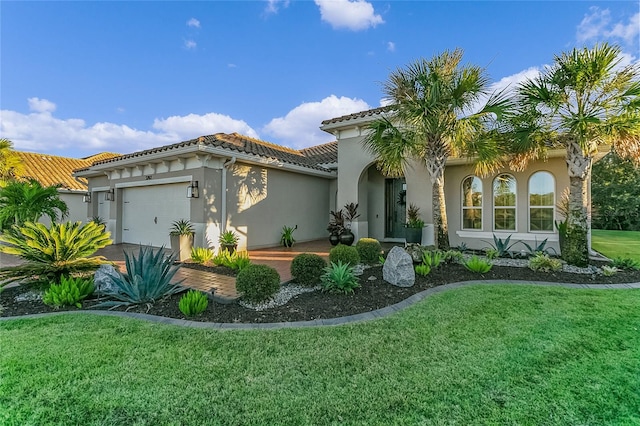 mediterranean / spanish-style home featuring a garage and a front lawn