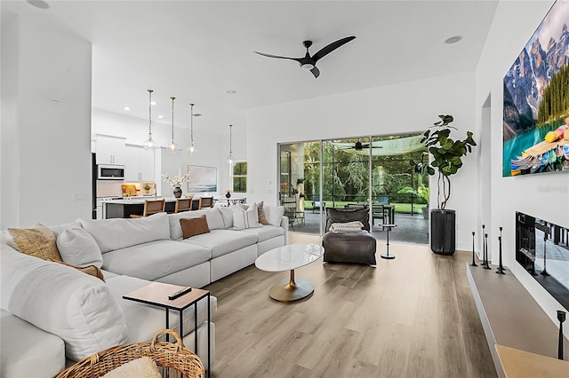 living room featuring ceiling fan and light hardwood / wood-style floors