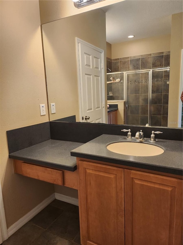 bathroom with tile patterned flooring, vanity, and walk in shower