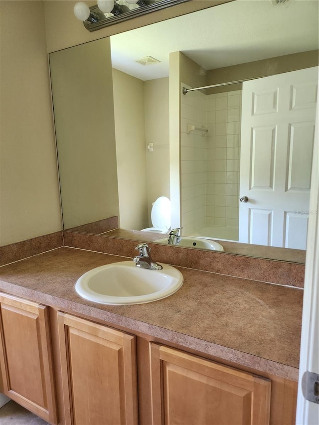 bathroom featuring vanity and tiled shower / bath