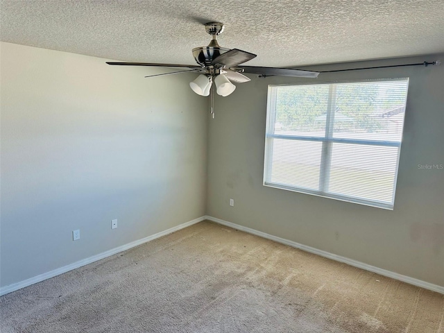 unfurnished room with a textured ceiling, ceiling fan, and light carpet