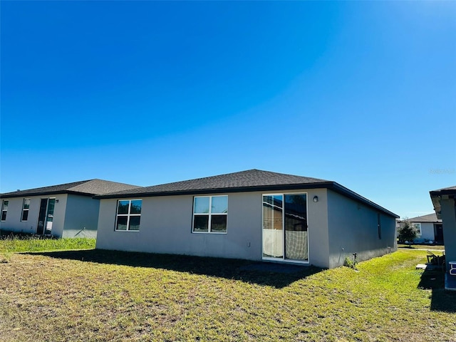 back of property featuring a lawn