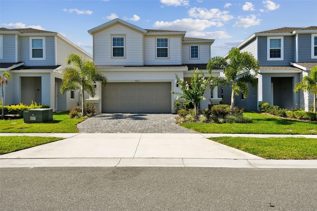 view of front of property with a front yard, central AC, and a garage