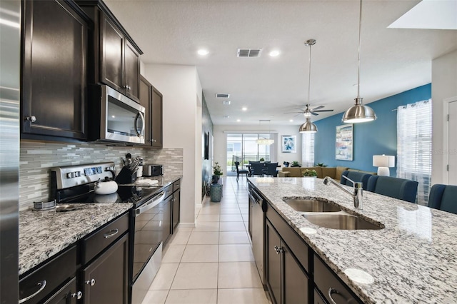 kitchen with ceiling fan, sink, stainless steel appliances, tasteful backsplash, and decorative light fixtures