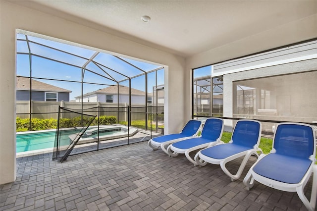 view of patio featuring a swimming pool with hot tub and glass enclosure