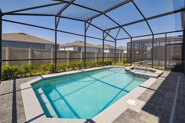 view of pool with a patio area, a lanai, and an in ground hot tub