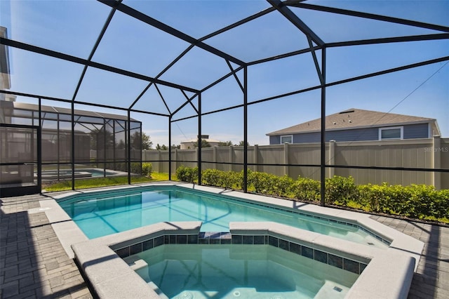 view of swimming pool with a lanai and an in ground hot tub