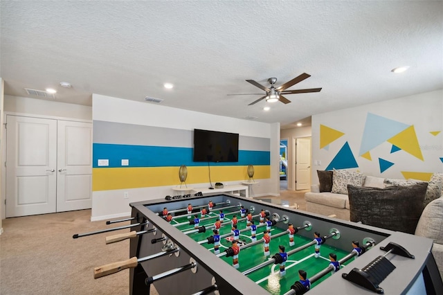 game room featuring carpet flooring, ceiling fan, and a textured ceiling