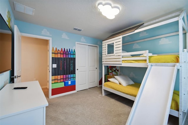 carpeted bedroom featuring a textured ceiling and a closet