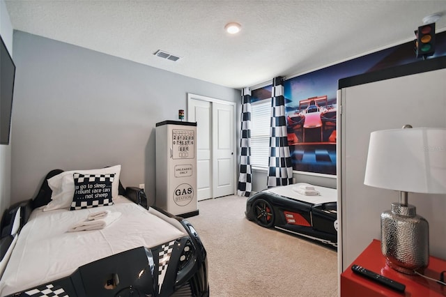 carpeted bedroom featuring a closet and a textured ceiling