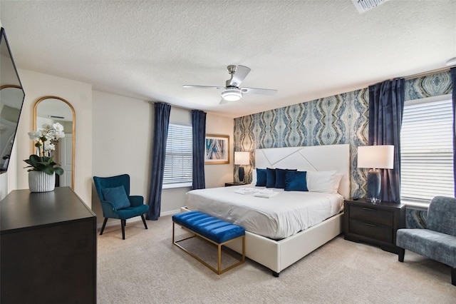 bedroom featuring carpet flooring, ceiling fan, and a textured ceiling