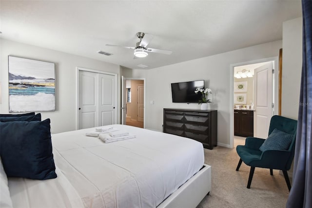 carpeted bedroom with ensuite bath, ceiling fan, and a closet