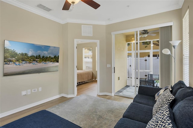 living room featuring light hardwood / wood-style floors and crown molding