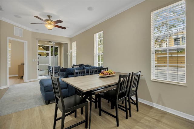 dining room featuring ceiling fan, plenty of natural light, light hardwood / wood-style floors, and ornamental molding