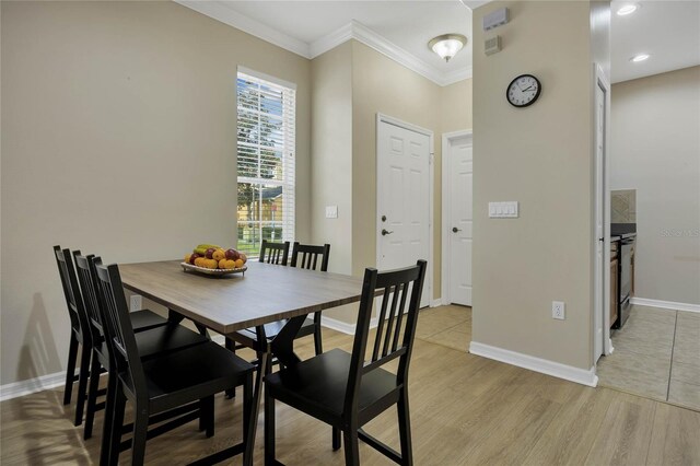 dining room featuring light wood-type flooring and ornamental molding