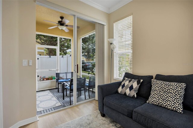 living room featuring ceiling fan, a healthy amount of sunlight, crown molding, and light hardwood / wood-style flooring