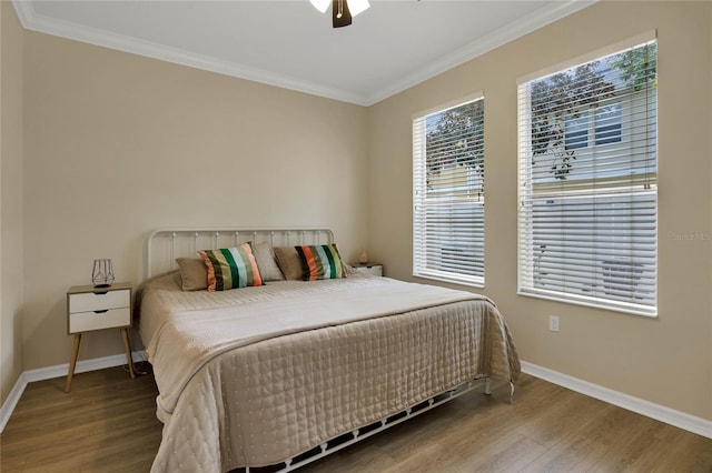 bedroom featuring ceiling fan, wood-type flooring, and ornamental molding