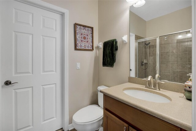 bathroom with vanity, toilet, and an enclosed shower