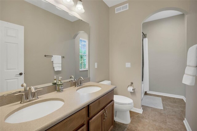 bathroom with tile patterned floors, vanity, and toilet