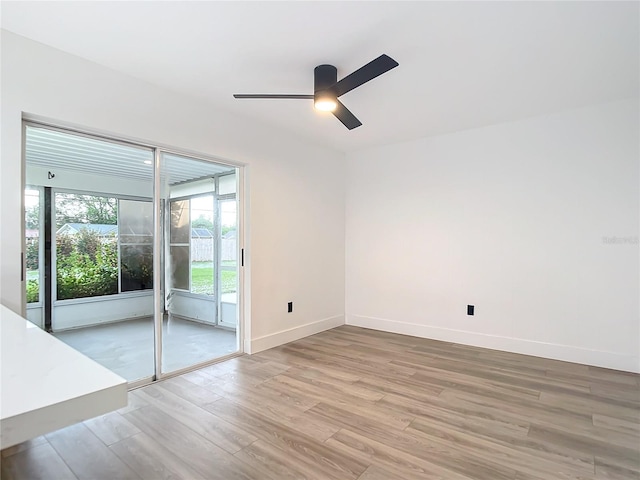 spare room with ceiling fan and light wood-type flooring