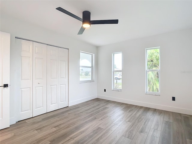 unfurnished bedroom with light wood-type flooring, a closet, and ceiling fan