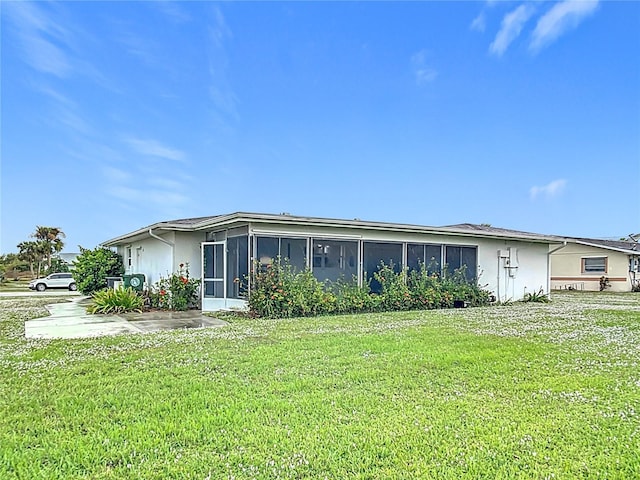 view of front of property featuring a front yard and a sunroom